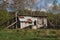 An old well next to an abandoned wooden shed