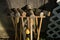 Old well-used Croquet mallets in a rack leaning against a wooden wall, at a downward angle