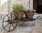 Old wheelbarrow with baskets of flowers