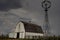 Old white barn sitting under thunder storm clouds.