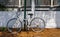 Old White Bicycle Chained to Green Pole