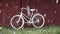 Old white bicycle near barn in farm and snowstorm