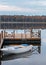 Old white boat with blue oars near the wooden pier