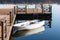 Old white boat with blue oars near the wooden pier