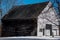 Old white and brown New England barn in a snowy field