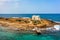 Old white church in a small island at sunset in Malia, Crete, Greece.