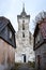 Old white countryside church with tower near small houses in old countryside city