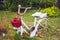 Old white decorative bicycle with a red basket and white galoshes in the garden