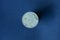 old white denmark coin on blue background