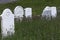 Old white gravestones in grassy cemetery