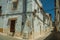 Old white houses with peeling plaster on deserted alley