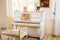 Old white piano in vintage interior