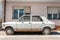 Old white rusty Fiat Zastava 101 car made in Kragujevac city, abandoned on the street.