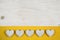Old white shabby chic background with five hearts and yellow fab