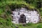 Old white shed of stones on a hillside