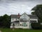 Old white two story house with peeling paint