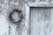 Old white wooden door with a wreath of ivy on it