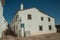 Old whitewashed house in front a cobblestone square