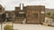 An old wild west looking buildings with an aerial pull up to the desert in the background.