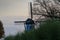 Old windmill with bushes in the late afternoon light and cloudy sky near Bruges