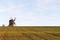 Old windmill by a farmers corn field