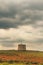 An old windmill in the field on a thunderstorm day