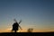 Old windmill silhouette by sunset