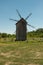 Old windmill wooden mill in countryside.Architectural wooden structure on  grass