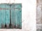 old window with blue mint color wooden old shutters on concrete wall background, house need maintenance
