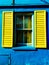 Old window with bright yellow shutters