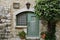 Old window and door of medieval house under tree