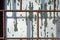 Old window painted by white paint behind a rusty brown bars. Abstract background