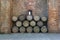 Old wine barrels stacked against a rustic brick wall
