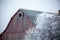 Old Wisconsin weathered barn next to trees covered with frost