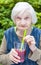 Old woman with alzheimer disease drinking raspberry juice