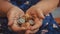 Old woman begs for alms. Closeup of money and coins in hand of poor woman