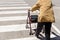 An old woman crosses a pedestrian crossing with the help of a rollator walker