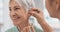 Old woman, doctor hands and patient with hearing aid, help and support with healthcare in clinic. Person with disability