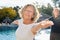 Old woman doing yoga exercise in workshop by the pool