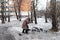 Old woman and doves in square at winter time. Pension concept.