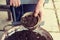 Old woman filling a pot with fresh soil. Symbol of spring