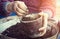 Old woman filling a pot with fresh soil. Symbol of spring