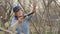 Old woman gardener using saw for sawing tree branches while gardening work