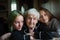 An old woman granny is photographed for portrait with her great-granddaughters. Family.