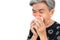 An old woman have a cold, uses a tissue to cover her mouth when coughing and sneezing