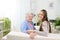 Old woman at home with cheerful young girl spending time together with laptop computer