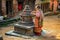 Old woman lighting a candle in the street of Kathmandu, Nepal