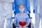 Old woman patient hold mini heart on a bed with background of the medical team thumbs up