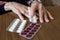 Old woman preparing her pills with medical remote assistance button on the wrist