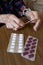 Old woman preparing her pills with medical remote assistance button on the wrist